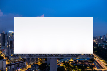 Blank white road billboard with KL cityscape background at night time. Street advertising poster, mock up, 3D rendering. Front view. The concept of marketing communication to promote or sell idea.