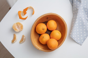 Top view of fresh mandarin oranges or tangerines in the wooden bowl