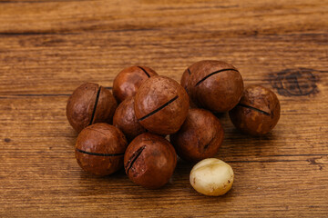 Brown macadamia nut heap over background