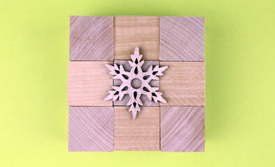 Background from wooden cubes with wooden snowflake
