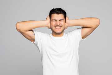 Fototapeta na wymiar Young man covering his ears and shouting isolated on a white background