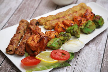 Mix Kebab skewers Served with mint sauce wooden background with glass of water 