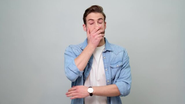 Confused young man in denim jacket over light grey background put palm on face facepalm gesture