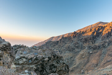 Barren mountain in Darband valley in dawn against colorful sky in the Tochal mountain with background of Tehran city in the morning. A popular recreational region for Tehran's residents