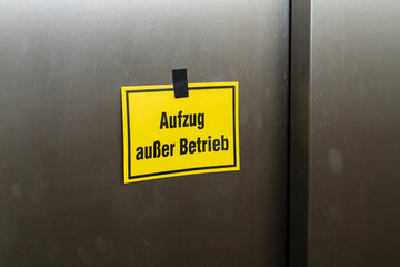 Gelber Zettel mit der Aufschrift , Aufzug außer Betrieb , an der Fahrstuhltür