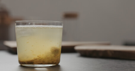 lulo fruit drink with ice in tumbler glass on concrete countertop