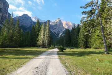 A gravelled pathway leading through a valley in Italian Dolomites. High and sharp mountains around....