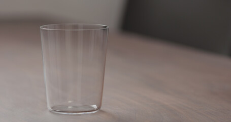 tumbler glass on walnut table with copy space