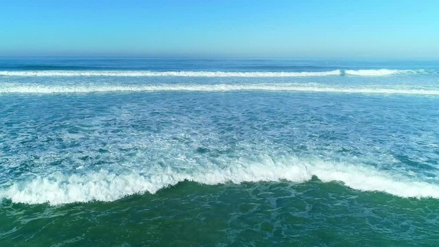 At the broad west seacoast of Portugal, waves surge against the seacoast in a row.
