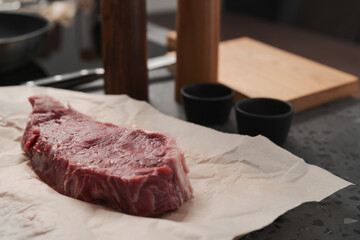Raw new york sirloin steak on parchment paper warming up before cooking
