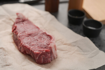 Raw new york sirloin steak on parchment paper warming up before cooking