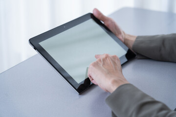 タブレットを使う中年女性の手