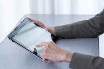 タブレットを使う中年女性の手