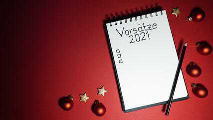 notebook with goal list 2021 red background Vorsätze german language
