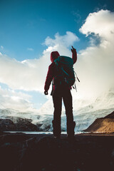 Strong woman backpacker hiking in winter mountains