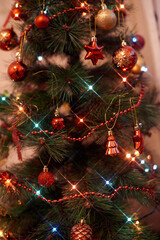 Close up of a decorated Christmas Tree with colourful decorations and garland lights, bokeh. Festive and New Year concept.