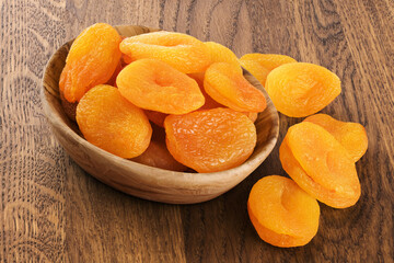 Dried apricots on a wooden background.