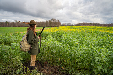 Treibjagd - junge Jägerin auf einer Treibjagd mit einem Gewehr im Anschlag, jagdliches Symbolfoto.