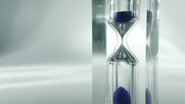 Raw time lapse macro video of modern hourglass, sandglass close-up. Sand texture, falling sand. 