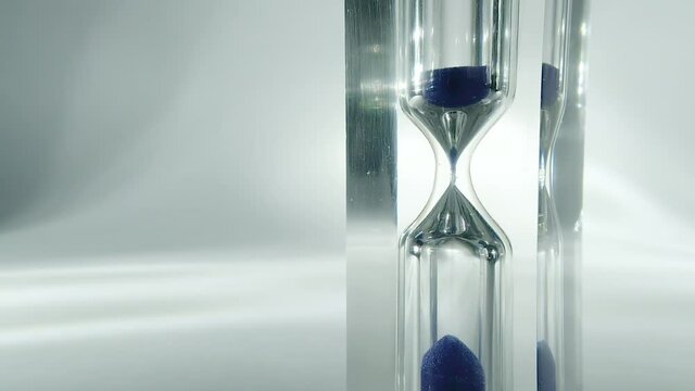 Raw time lapse macro video of modern hourglass, sandglass close-up. Sand texture, falling sand. 