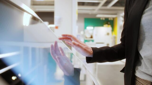 Woman using interactive touchscreen display scrolling and touching. Entertainment and technology concept.
