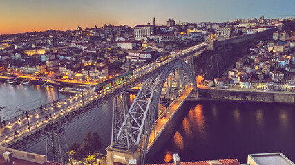 Ponte Dom Luis I com o passar de metros, cheio de luminação e casas antigas Porto.  - obrazy, fototapety, plakaty
