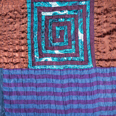 textile background - hand-crafted detail of patchwork fabric with spiral pattern