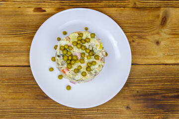 Traditional Russian festive salad Olivier on wooden table. Top view
