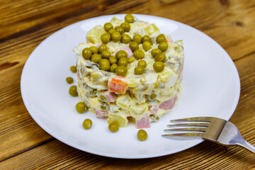 Traditional Russian festive salad Olivier on wooden table