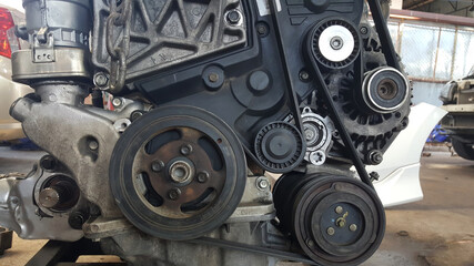 Close-up on a disassembled engine with a view of the gas distribution mechanism, chain, gears and tensioners during repair and restoration after a breakdown. Auto service industry.
