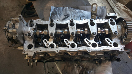 Close-up on a disassembled engine with a view of the gas distribution mechanism, chain, gears and tensioners during repair and restoration after a breakdown. Auto service industry.