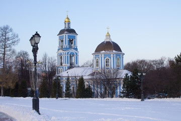 Orthodox blue Church of the icon of the mother of God in Tsaritsyno Park on a clear winter day against the background of snow and bare trees with space to copy in Moscow Russia