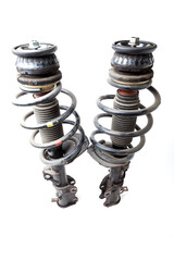 Two shock absorber struts with black springs after being used on a car during replacement and...