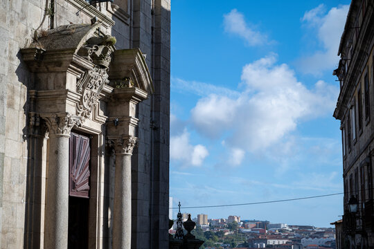 Facade of the Igreja Paroquial de Nossa Senhora da Vit&oacute;ria (Parish Church of Nossa Senhora da Vit&oacute;ria). Details worked in stone. City in the background. Blue skie with clouds.