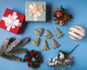 Festive Christmas and new year decorations with gingerbread, gift boxes ,balls, cones on blue background