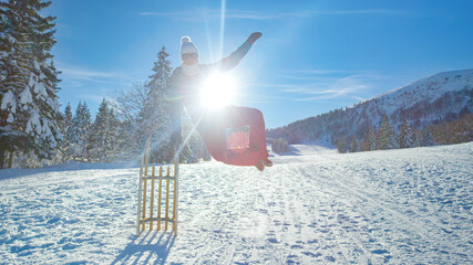 PORTRAIT: Cheerful female tourist clicks her heels while standing next to sleigh