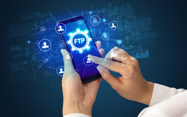 Female hand holding smartphone with FTP abbreviation, modern technology concept