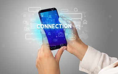 Female hand typing on smartphone with CONNECTION inscription, social media concept