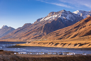 Fototapeta na wymiar Panoramic landscape of Spiti river valley and snow capped mountains during sunrise near Kaza town in Lahaul and Spiti district of Himachal Pradesh, India.