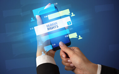 Female hand typing on smartphone with HUMAN RIGHTS inscription, social networking concept