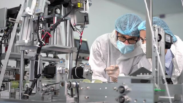 Staff and workers at the mask factory are monitoring the operation of the machines.