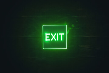 Exit sign light on the wooden wall background.