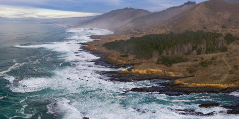 The cold waters of the Pacific Ocean wash against the rocky Northern California coastline in Mendocino. The scenic Pacific Coast Highway runs along this amazing part of the west coast.