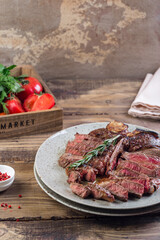 grilled red beef pork meat barbecue steak fillet with rosemary sprig and hot sauce served on plate