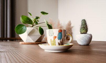 Turkish coffee cup on wooden table. Small cup with cactus pattern. Coffee cup with cactus and china money flower.