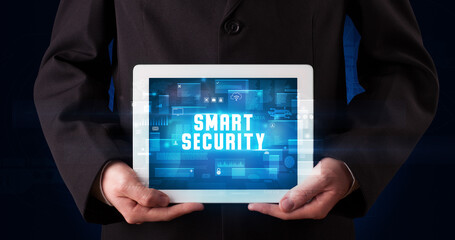 Young business person working on tablet and shows the digital sign: SMART SECURITY