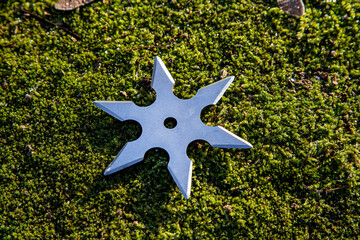 Shuriken (throwing star), traditional japanese ninja cold weapon stuck in wooden background