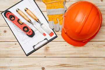Construction worker tools hardhat and chisel on wooden background