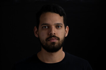 Obraz premium Closeup frontal portrait of young men serious over black background.