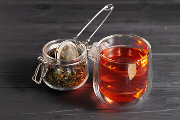 Glass cup of tea on wooden board